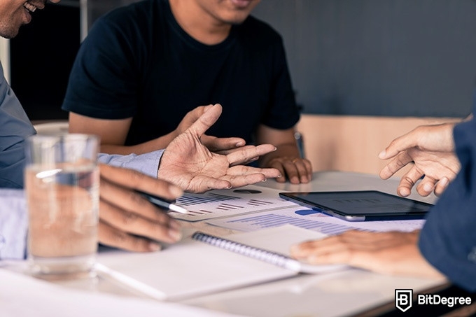 Best online finance degree programs: men are discussing data around the table.