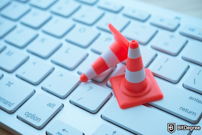 Cybersecurity Courses: safety cones on a laptop keyboard.