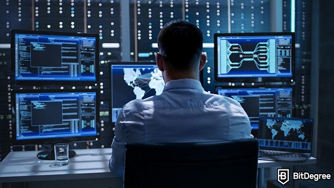 Cybersecurity Courses: man working with several monitors.