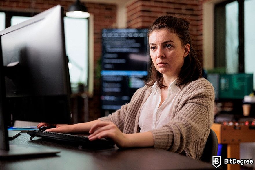DataCamp Python: A woman is working on a desktop computer.