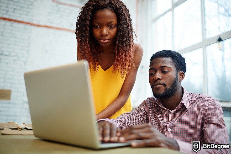 DataCamp SQL: a woman and a man are looking at a laptop.