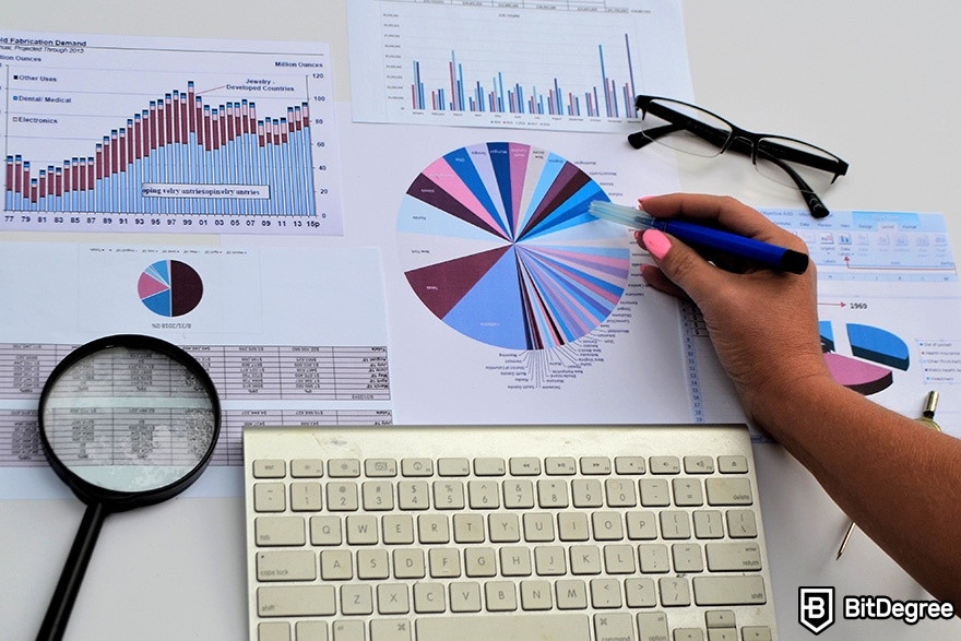 DataCamp Tableau: A hand is pointing at printed charts with a pen.