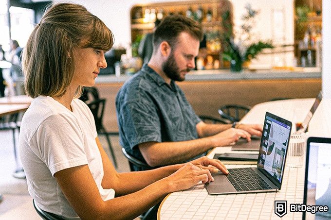 Digital Marketing Udemy: two coworkers working on laptops.