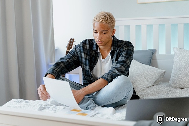 Distance Learning: a man is sitting on the bed and learning.