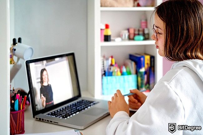 Distance learning: a teen girl watches an educational video.