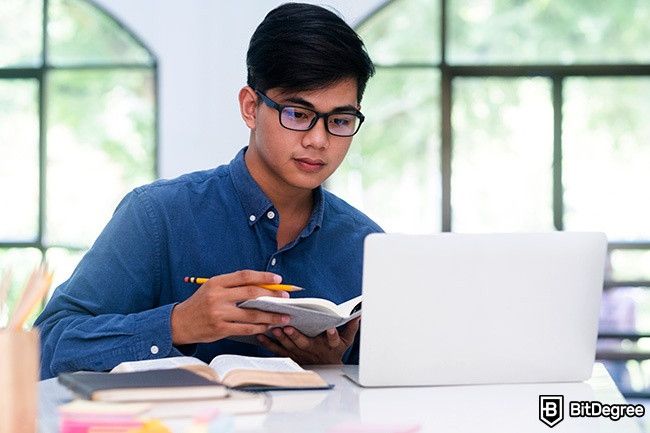 Distance Learning: man in glasses is taking notes.