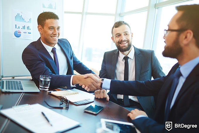 Harvard negotiation course: men shaking hands after an agreement.