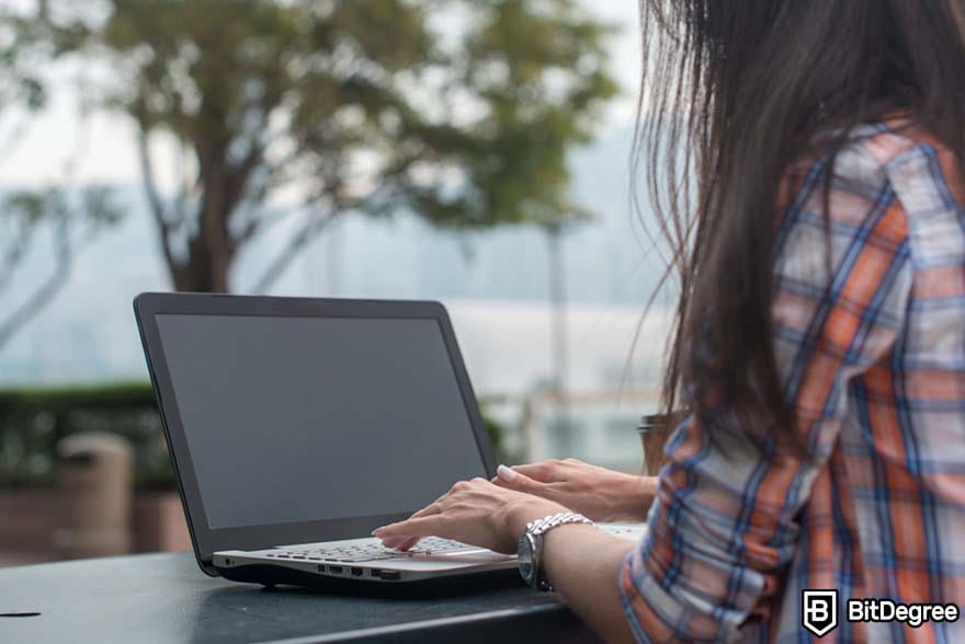 How to become a financial analyst: woman typing on computer. 