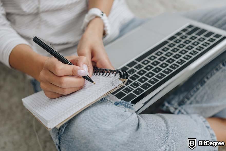 How to become a financial analyst: woman taking notes. 