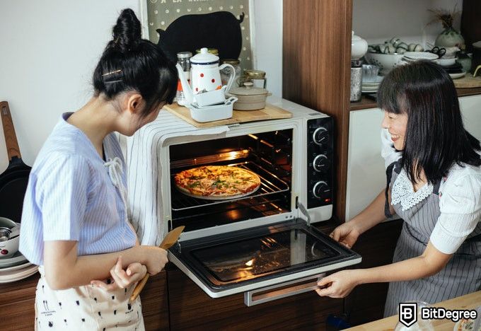 Học nấu ăn trực tuyến: hai người phụ nữ nhìn vào lò nướng