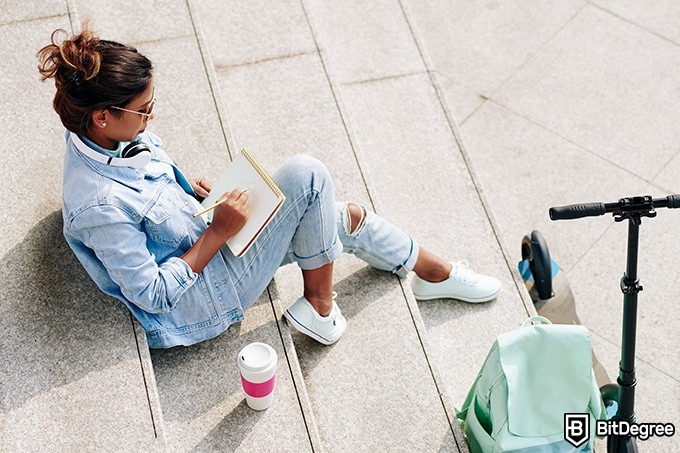 How to draw: a woman is sitting on the stairs outside and sketching.