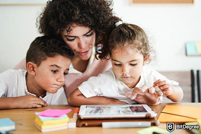 Cách học tại nhà: một người phụ nữ đang dạy hai đứa trẻ.