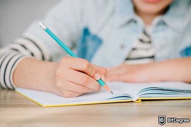 Cách học tại nhà: một đứa trẻ đang viết trên một cuốn sách.