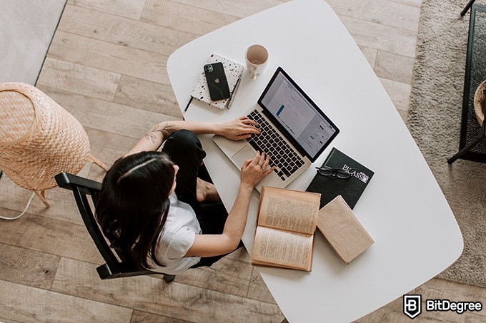 Hybrid Learning: a woman is seen from above studying on her laptop.