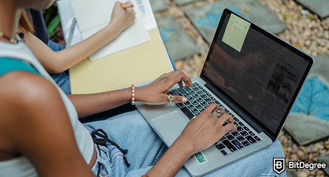 Hybrid Learning: two students are reading from a laptop.