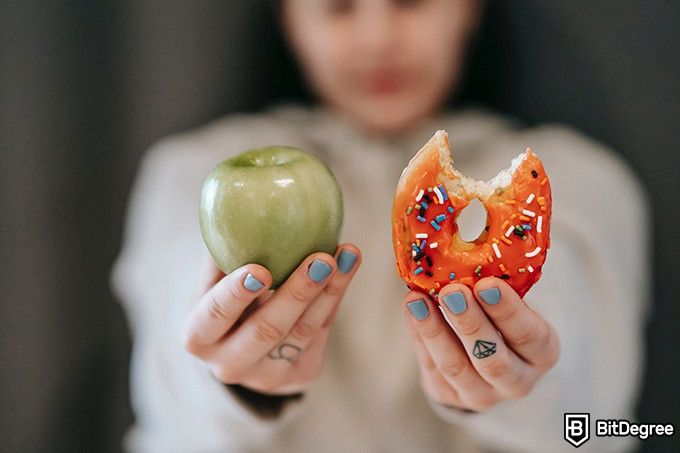 Nutrition courses online: a woman choosing between an apple and a donut.