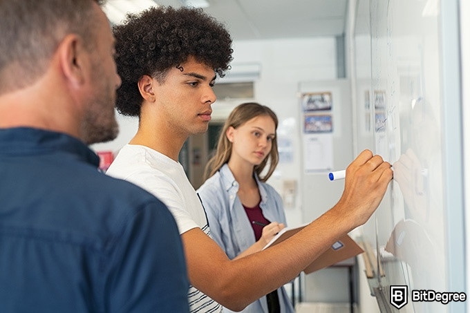 Online Algebra Course: people working at a whiteboard.