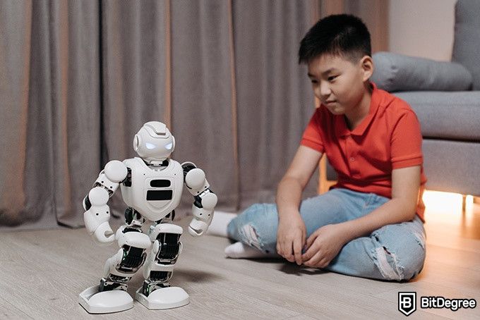 Online Artificial Intelligence Course: boy playing with a robot.