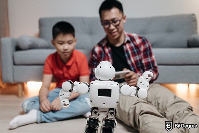 Online Artificial Intelligence Course: father and son playing with a robot.