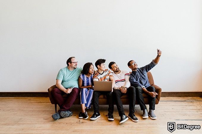 Online ethics courses: five people sitting on a sofa are taking a selfie.