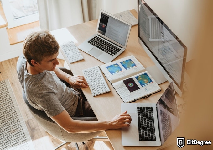 Online Healthcare Degrees: man working with multiple computers.