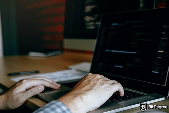 Graduação em tecnologia da informação online: duas mãos estão digitando no teclado de um laptop.