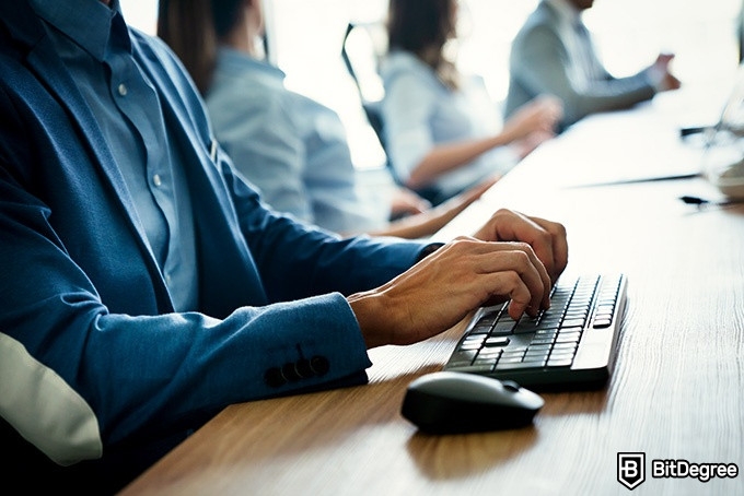 Online information technology degree: a man is typing on a keyboard.