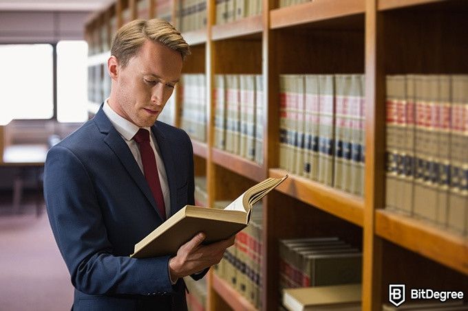 Online Law Courses: lawyer reading a book in the library.
