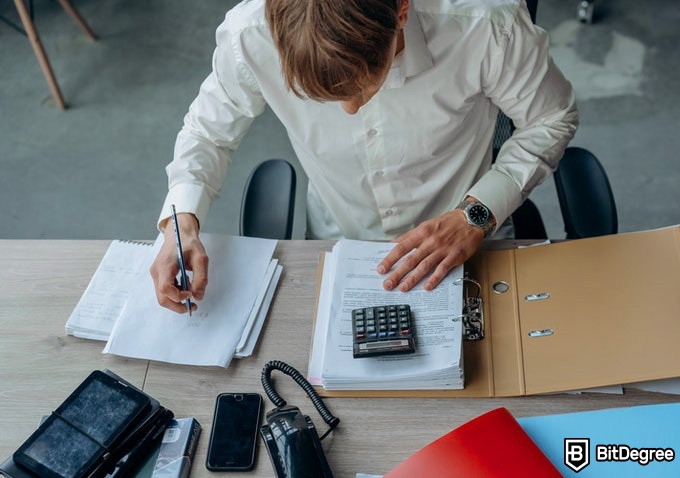 Online Math Courses: man using a calculator for his work