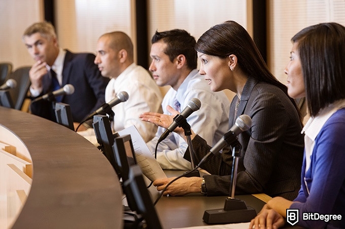 Online social sciences degree: a woman is delivering a speech at a conference.