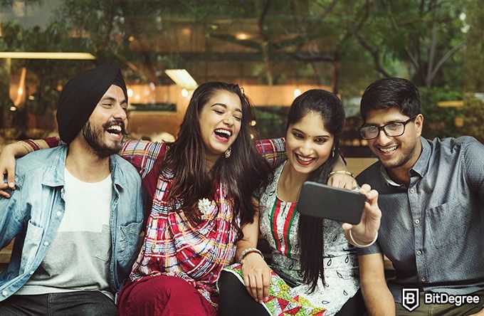 Online social sciences degree: four people are smiling while taking a selfie.