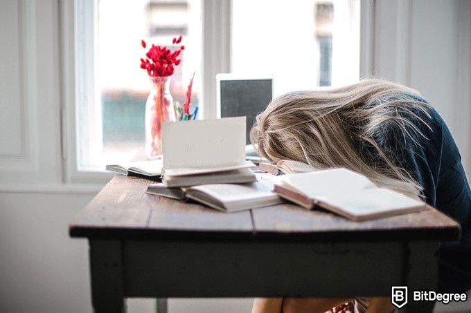 Online teaching courses: a woman sleeping on her desk.