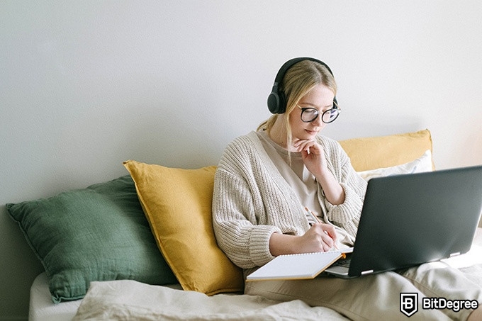 Online teaching courses: a girl studying on her bed.