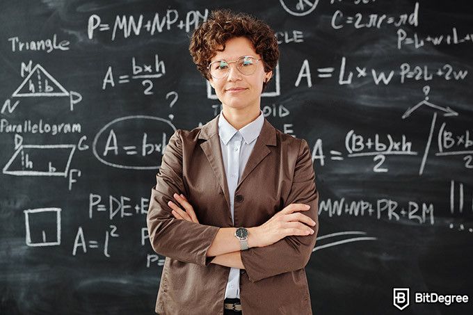 Online teaching courses: teacher standing in front of the blackboard.
