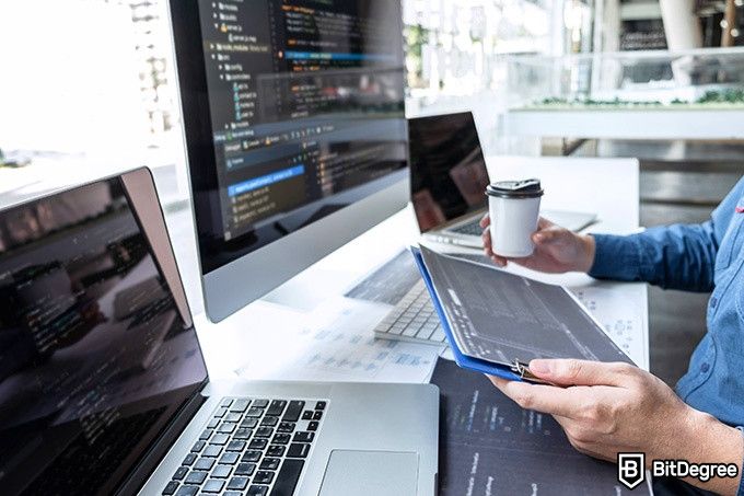 Developer Full-Stack Udacity: seorang lelaki sedang meminum kopi dan membaca code. 