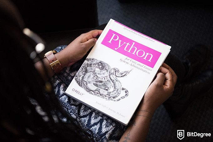 Top Udemy SQL Courses: person reading about Python on a tablet.