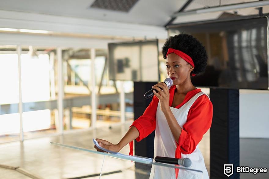 Public speaking classes online: a woman is speaking into a microphone.