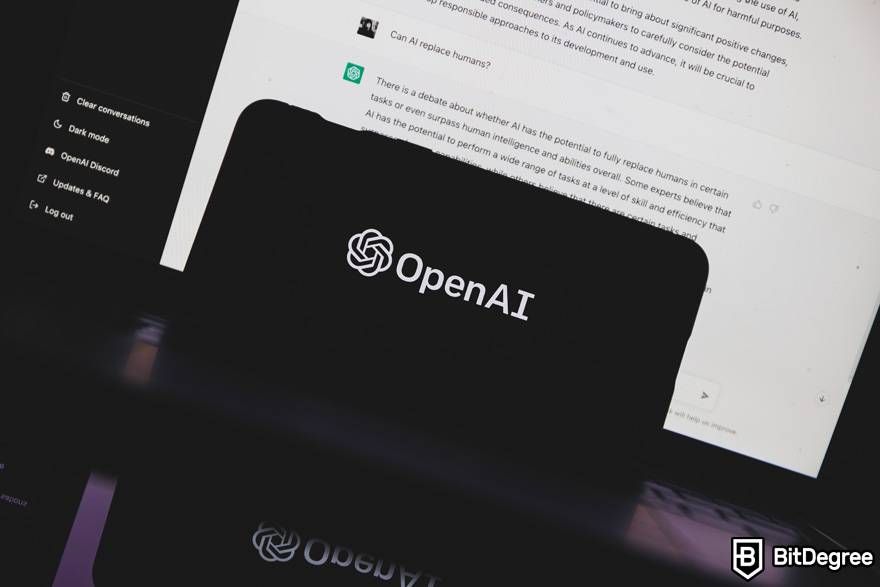 Where to learn ChatGPT: a phone is displaying the OpenAI logo. A laptop screen behind is showing ChatGPT.